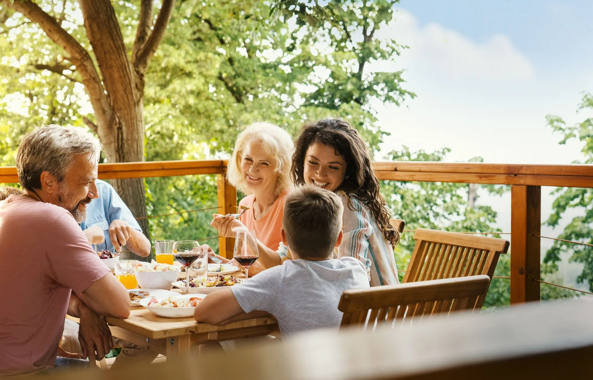 Family enjoying an outdoor deck and backyard living space